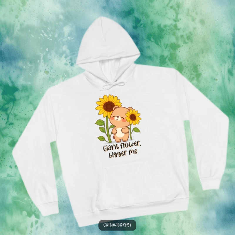 Funny hoodie showing a bear embracing its giggles next to a sunflower that's almost as tall as itself under a cheerful sky.